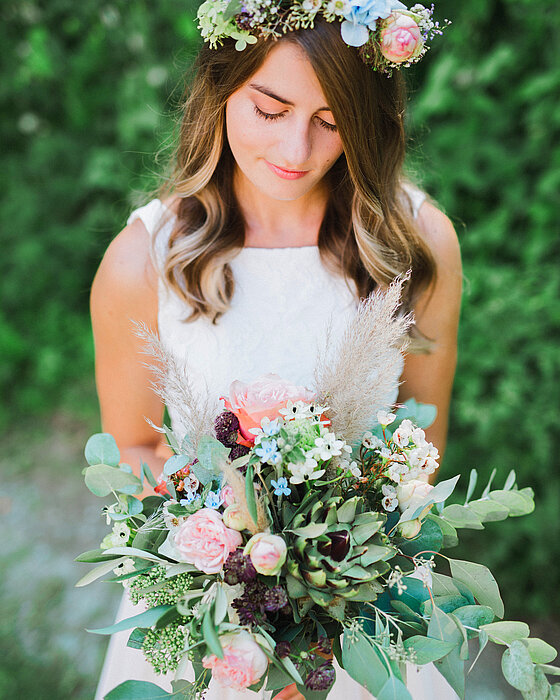 Braut mit Brautstrauß und Blumen im Haar. 