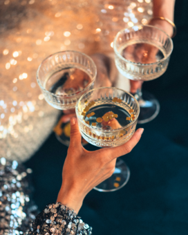 Frauen stoßen mit Sektschalen an.