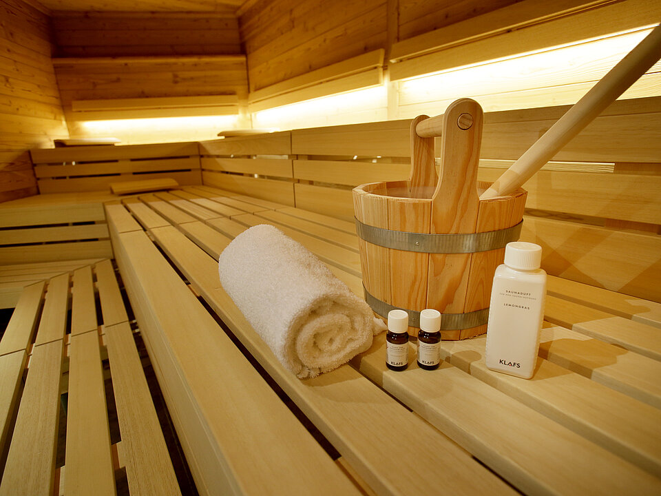 Sauna innen mit Saunaeimer, Handtuch und ätherische Öle